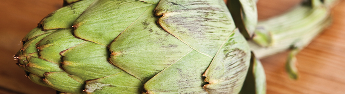 artichokes A green artichoke on a wooden surface