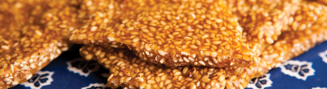 canape A close up of sesame seed crackers on a blue and white cloth