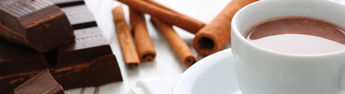 chocomex_0 A cup of hot chocolate next to some cinnamon sticks