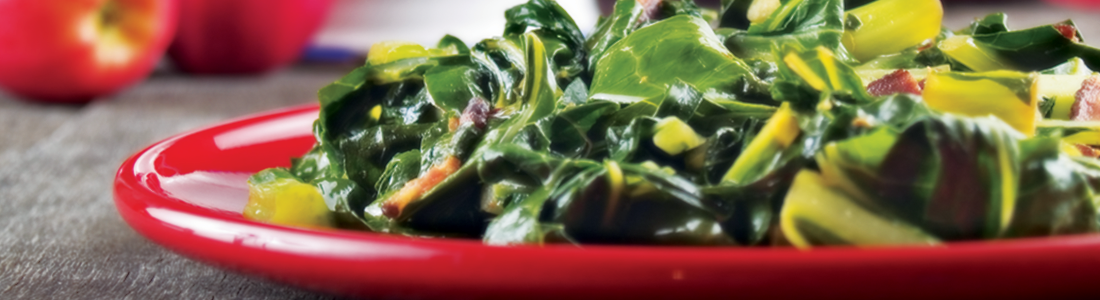 collardgreens A red bowl filled with greens on top of a table
