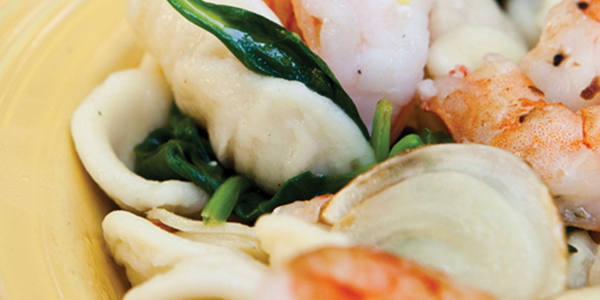 orecchiette A yellow plate topped with shrimp and pasta