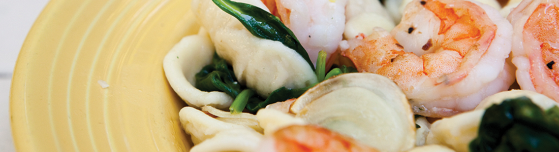 orecchiette A yellow plate topped with shrimp and pasta