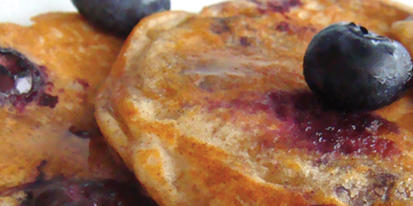 pancakes A white plate topped with pancakes covered in blueberries