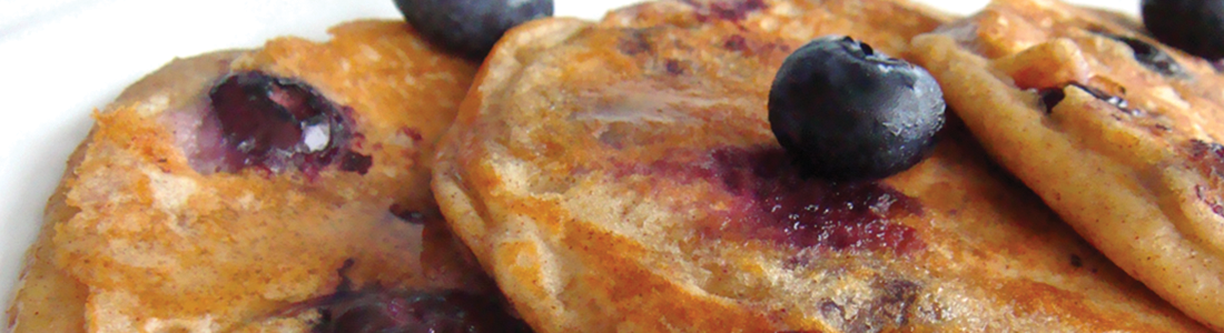 pancakes A white plate topped with pancakes covered in blueberries