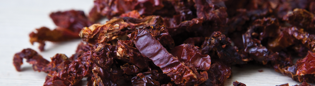 sundried A pile of dried red raisins sitting on top of a table