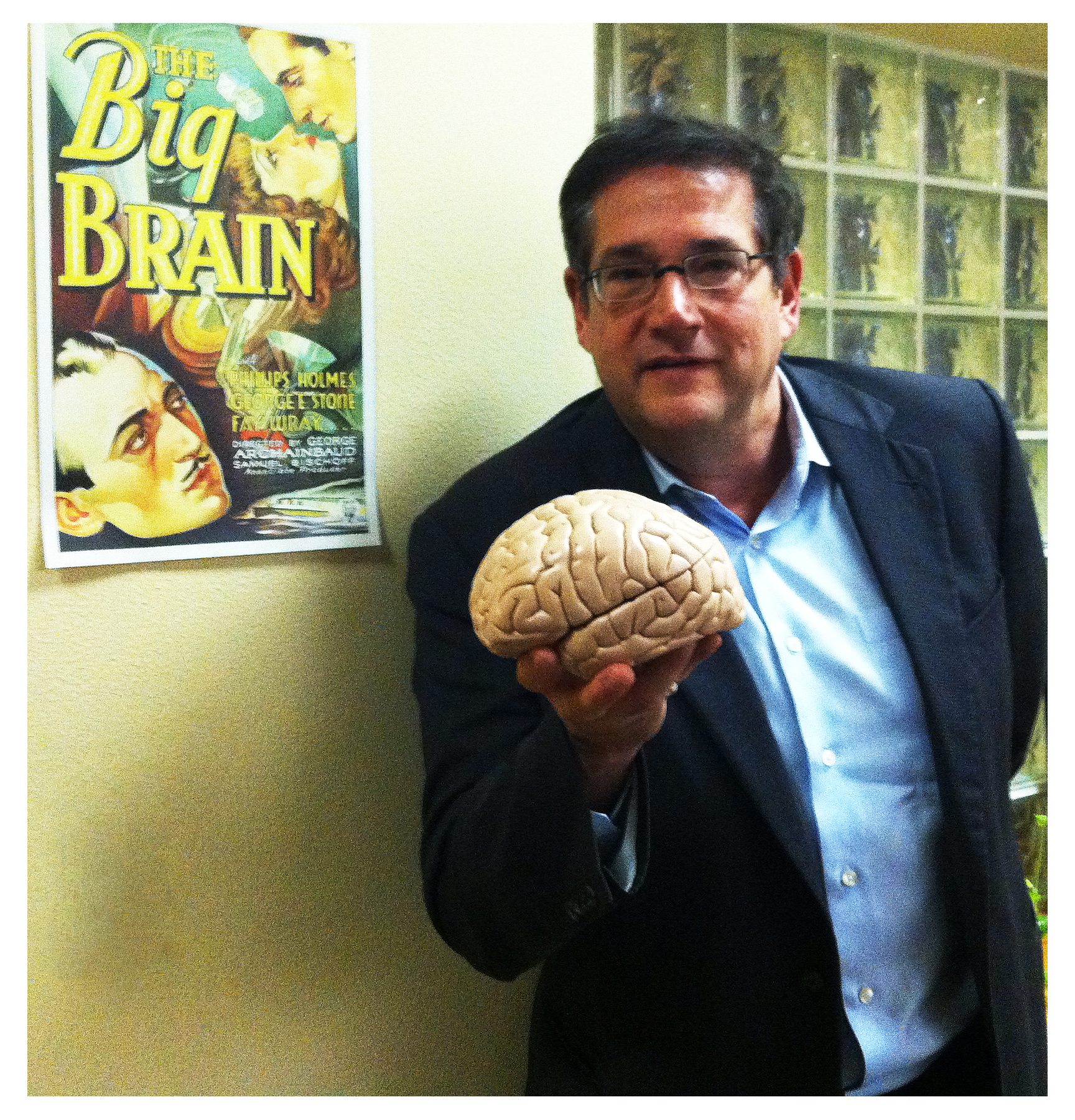JZ_001 Jeff Zimman holding a brain model in front of a poster