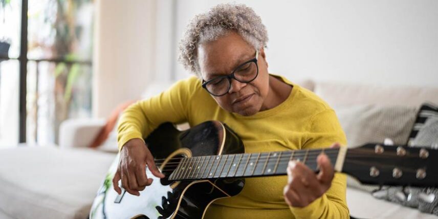 BrainPlasticity_1356377543_7 A woman sitting on a couch playing a guitar