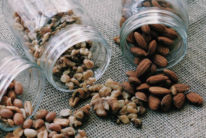 A couple of jars filled with nuts on top of a table