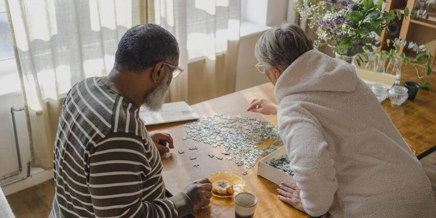 A man and woman sitting at a table playing a game