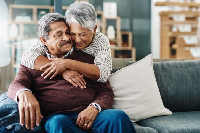 A man and woman hugging on a couch