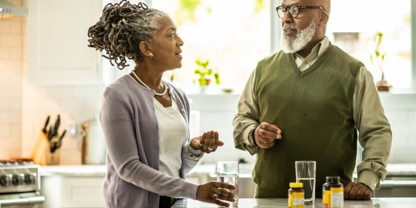 A man and a woman talking in a kitchen